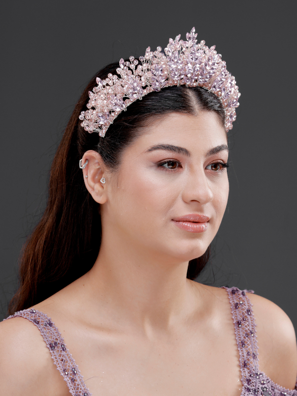 Pembe yoğun kristal kraliyet tacı – düz açık saçta ¾ görünüm, lila boncuklu elbise ile uyumlu narin ve prenses gibi gelin saç aksesuarı