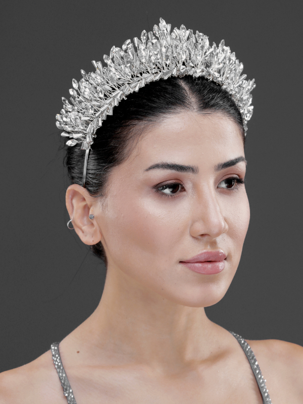 Gümüş kristal gösterişli gelin tacı – koyu saçta yan görünüm, ışıltılı yaprak motifli kraliyet esintili saç tacı düğün ve nişan törenleri için